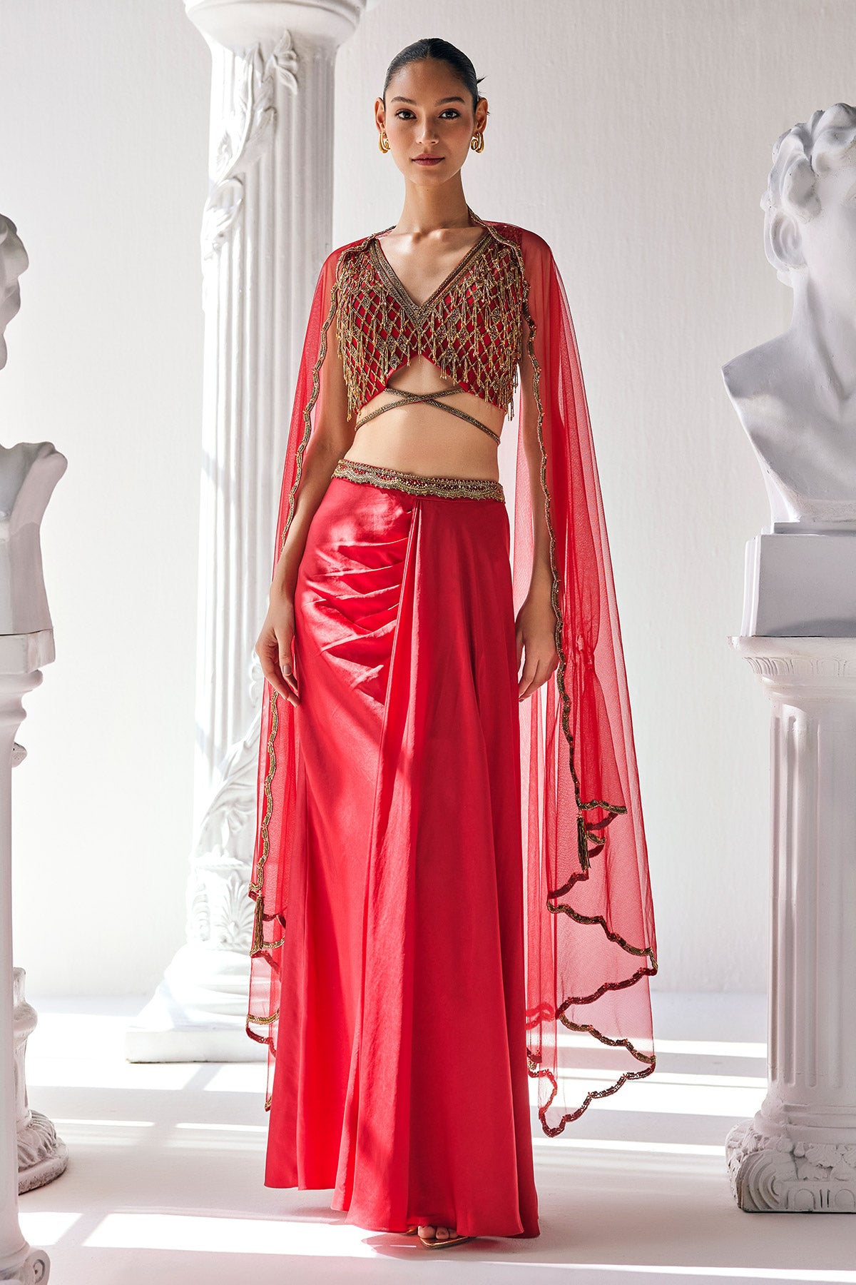 Elegant Red Ensemble Features A Royal Satin Skirt, Fully Embroidered Blouse, Belt And A Cape In A Soft Net.