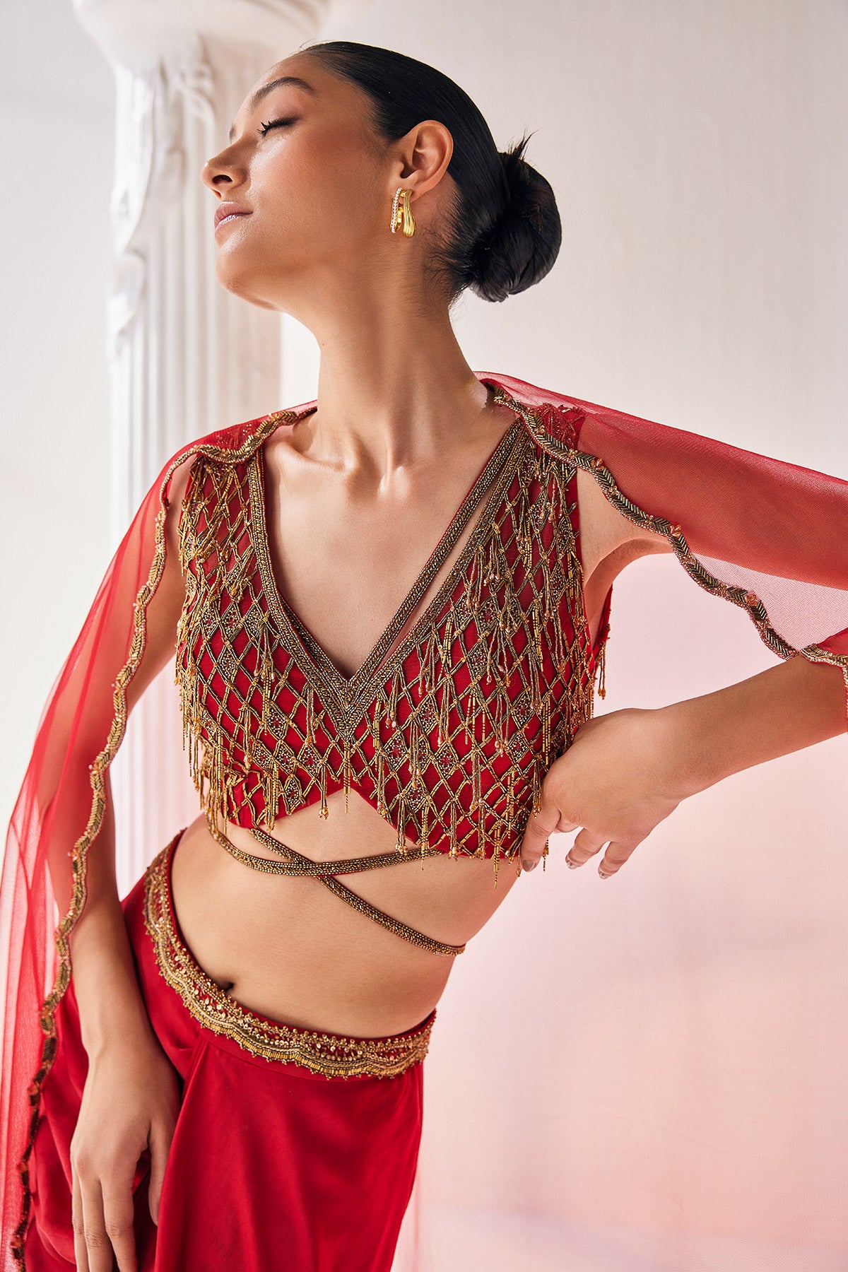 Elegant Red Ensemble Features A Royal Satin Skirt, Fully Embroidered Blouse, Belt And A Cape In A Soft Net.