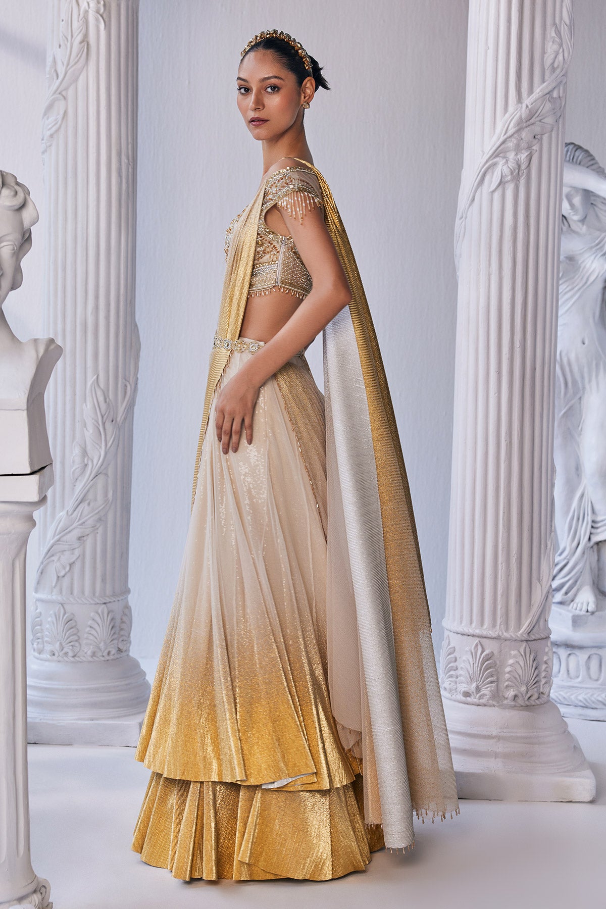 Draped Double Layer Lehenga In Pleated Gold Foil Lycra With An Emroideredwaistband Is Offset With A Corset.