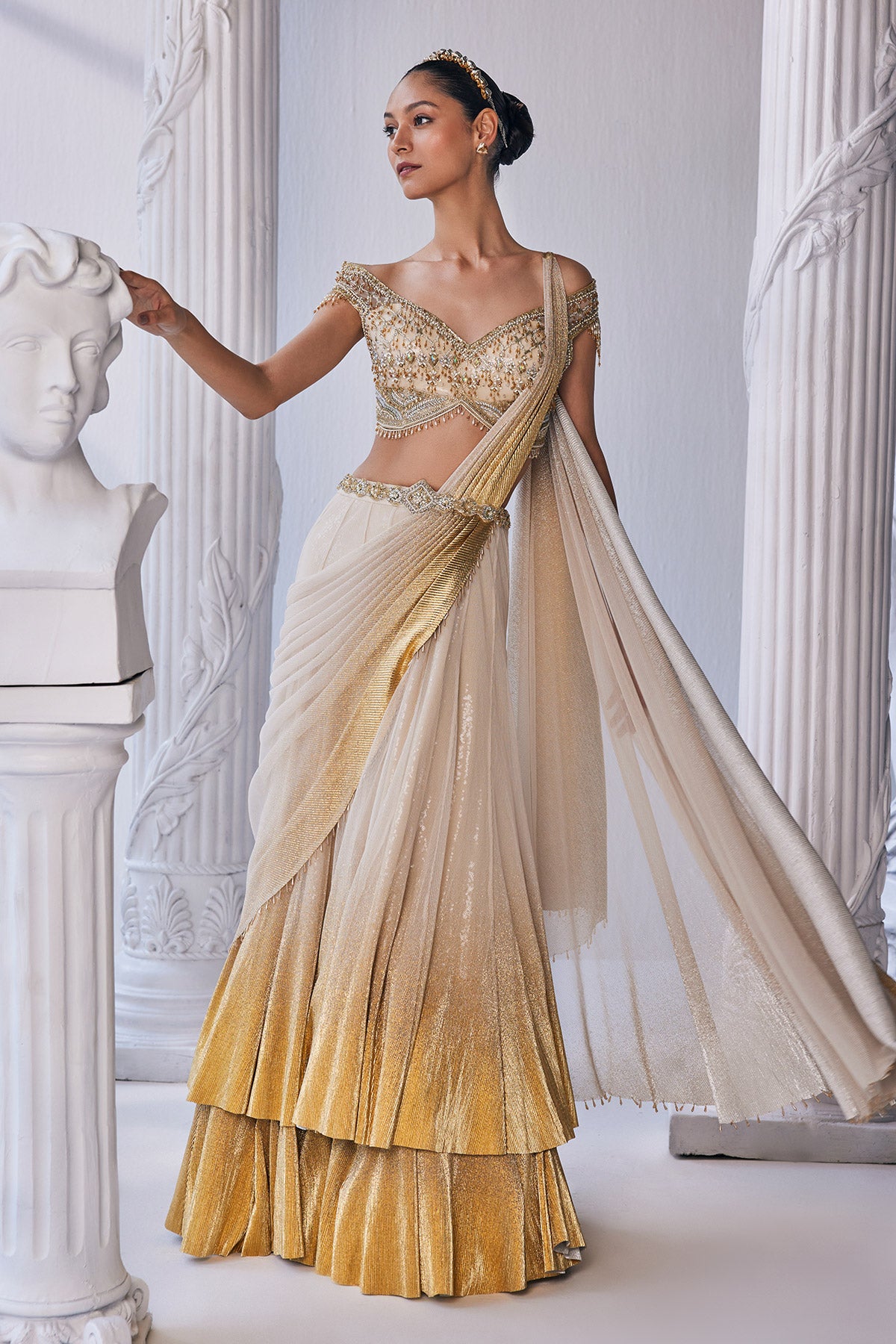 Draped Double Layer Lehenga In Pleated Gold Foil Lycra With An Emroideredwaistband Is Offset With A Corset.