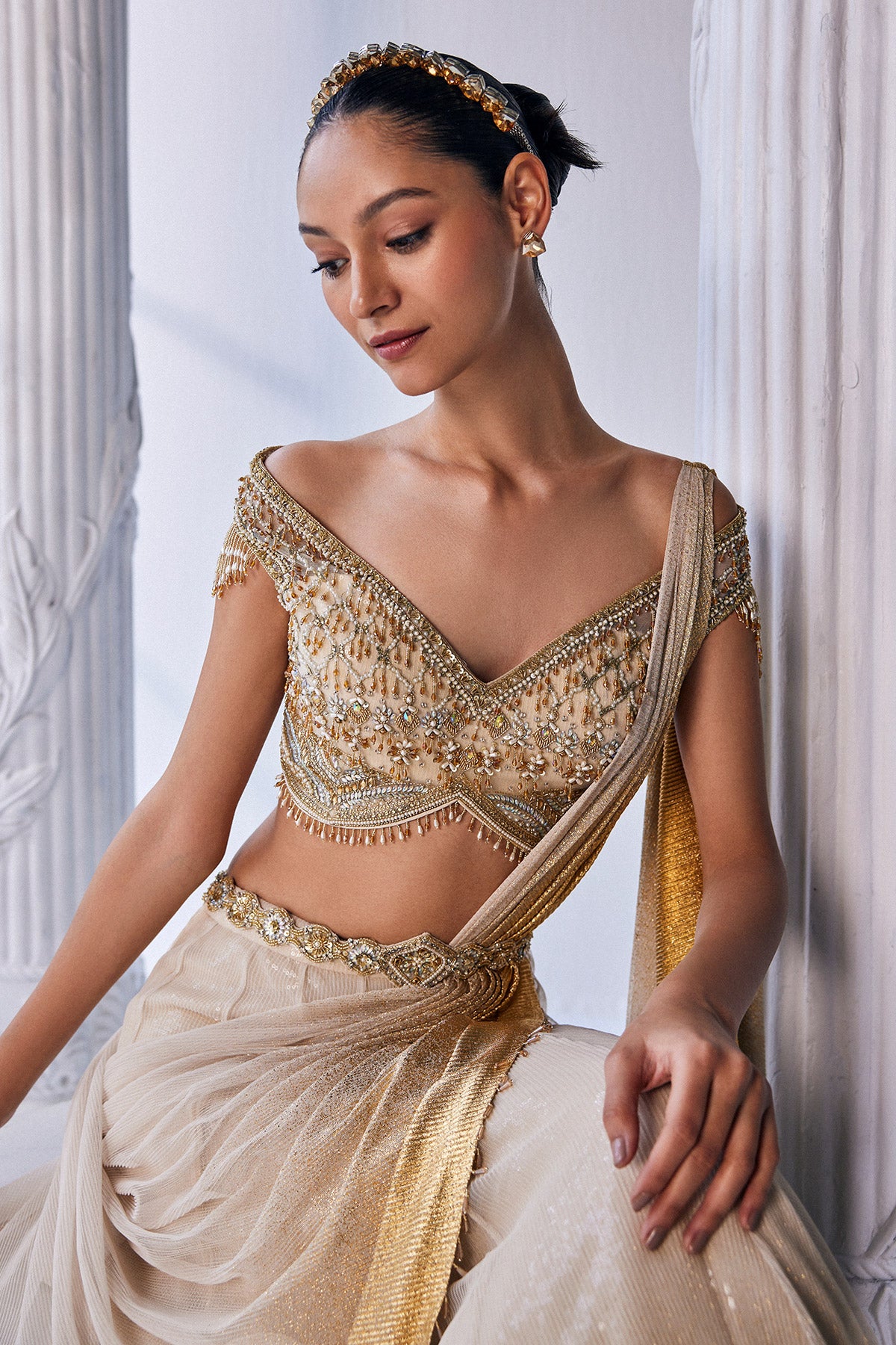 Draped Double Layer Lehenga In Pleated Gold Foil Lycra With An Emroideredwaistband Is Offset With A Corset.