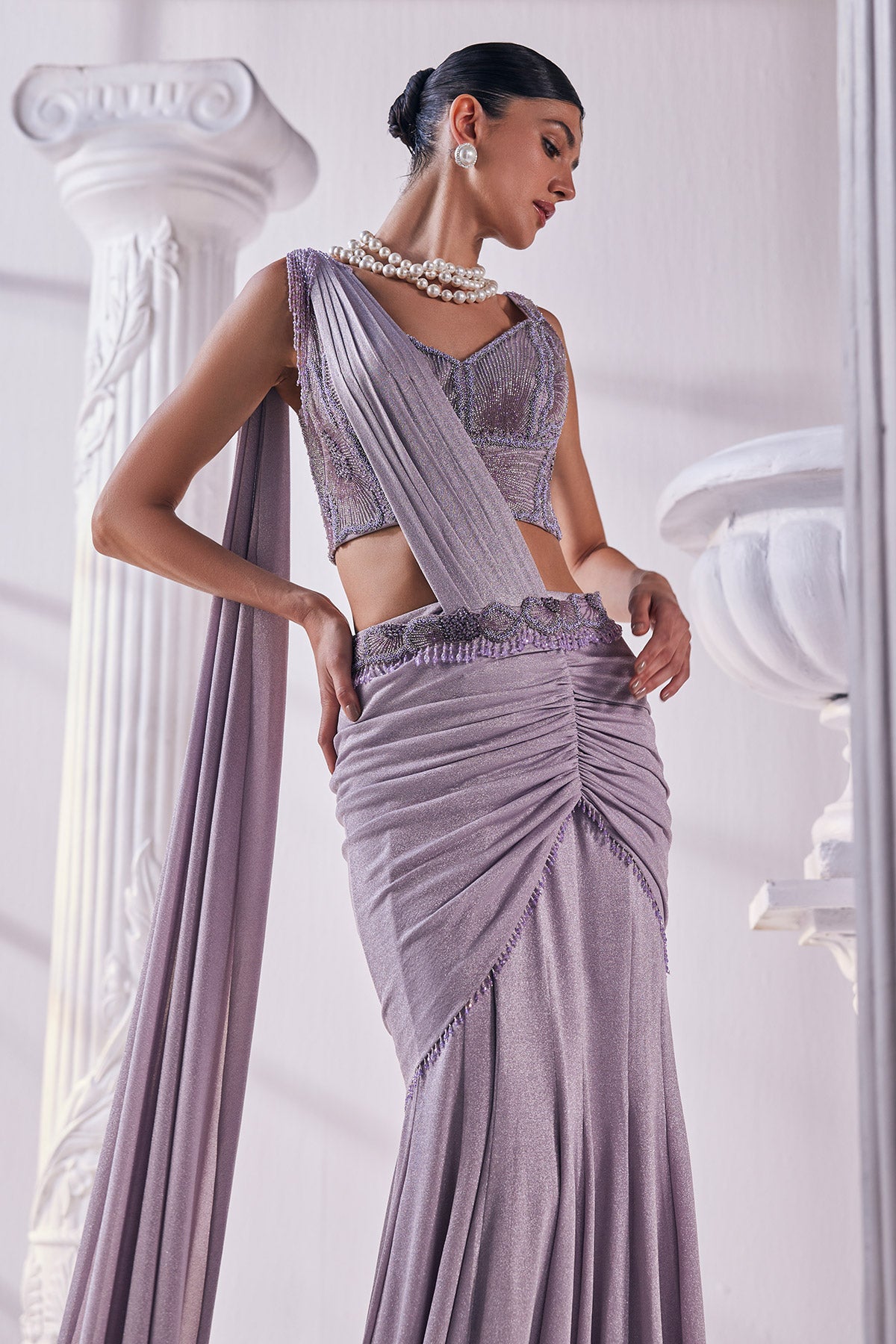 Draped Saree In Luxurious Shimmer Lycra Designed In Lilac Colour, An Emroidered Corset And A Belt.