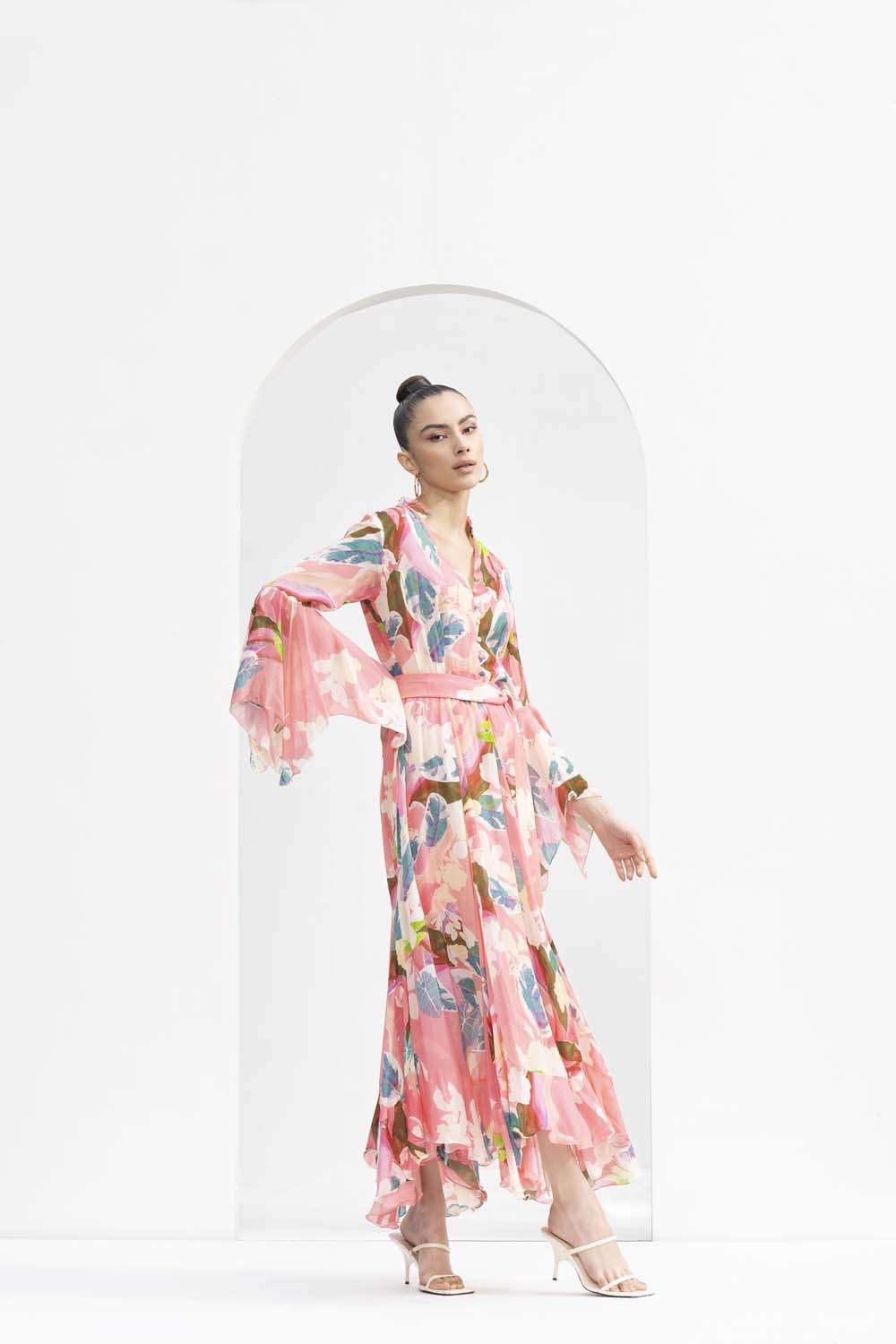 Peach tropical printed chiffon dress with godets and ruffled details on the neckline.