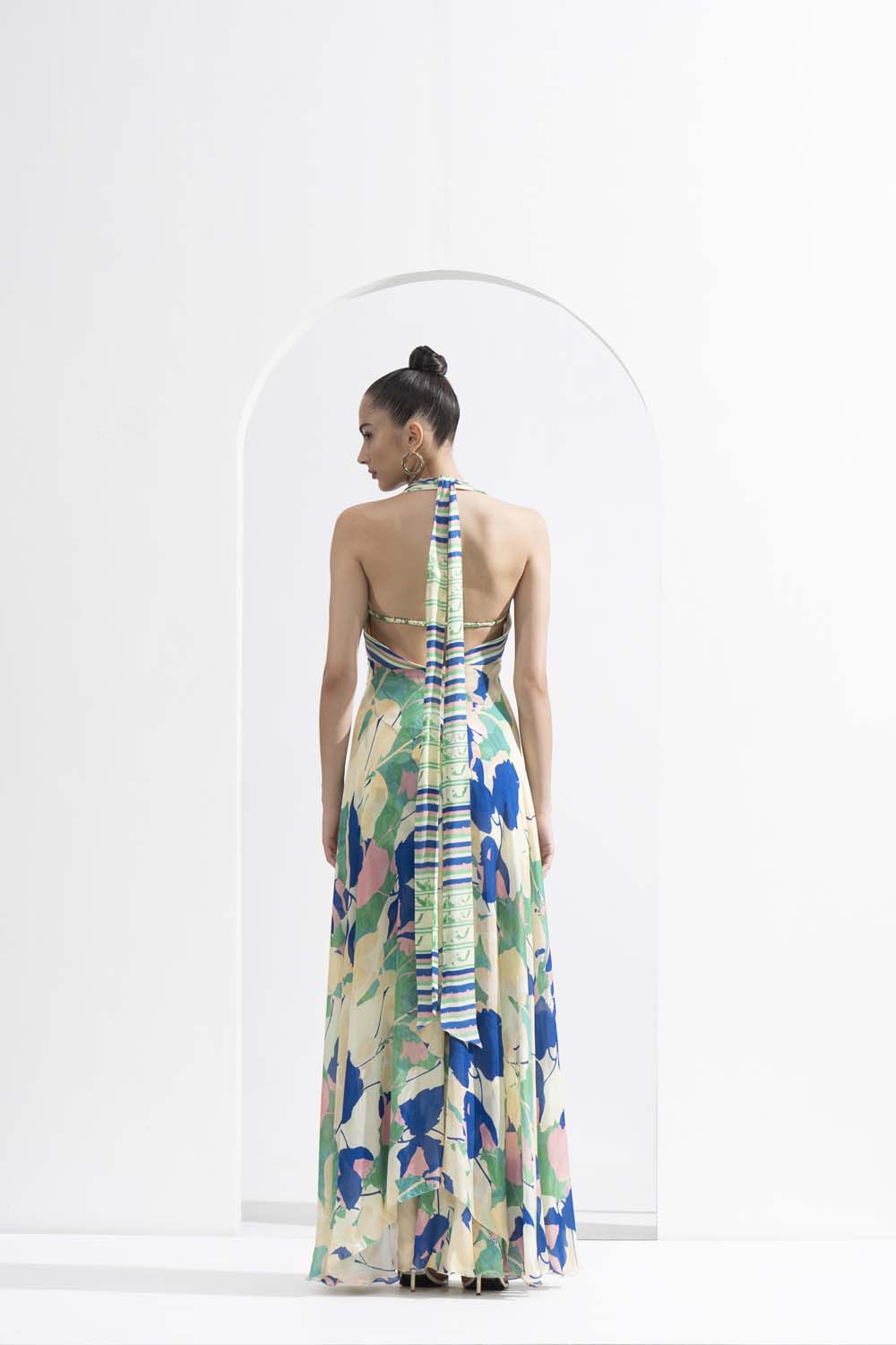 Mystic green chiffon placement printed draped halter neck dress with a silver accessory.