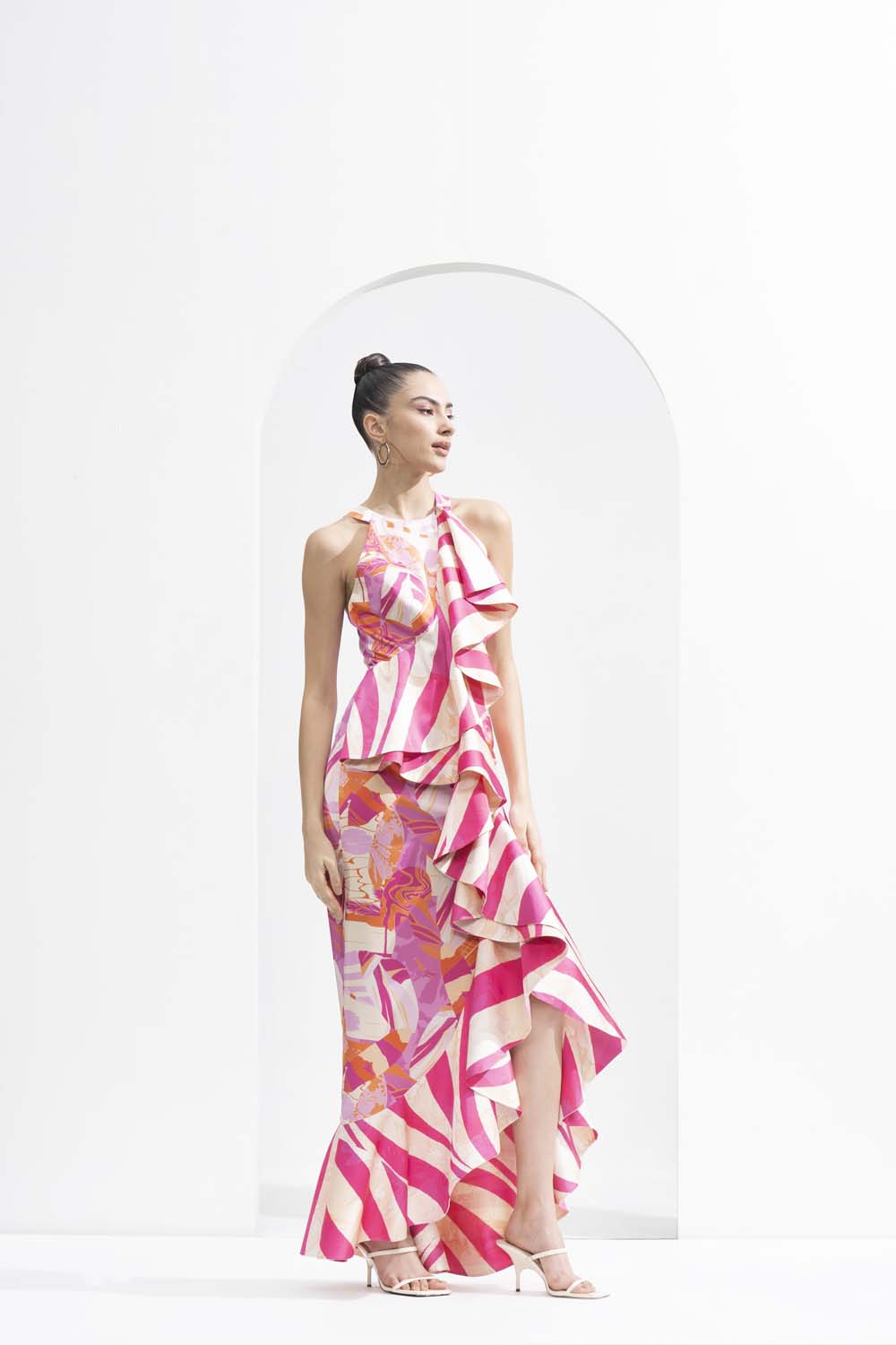 Pink abstract lustrous satin bodycon dress with an asymmetric frill and gold accessory.