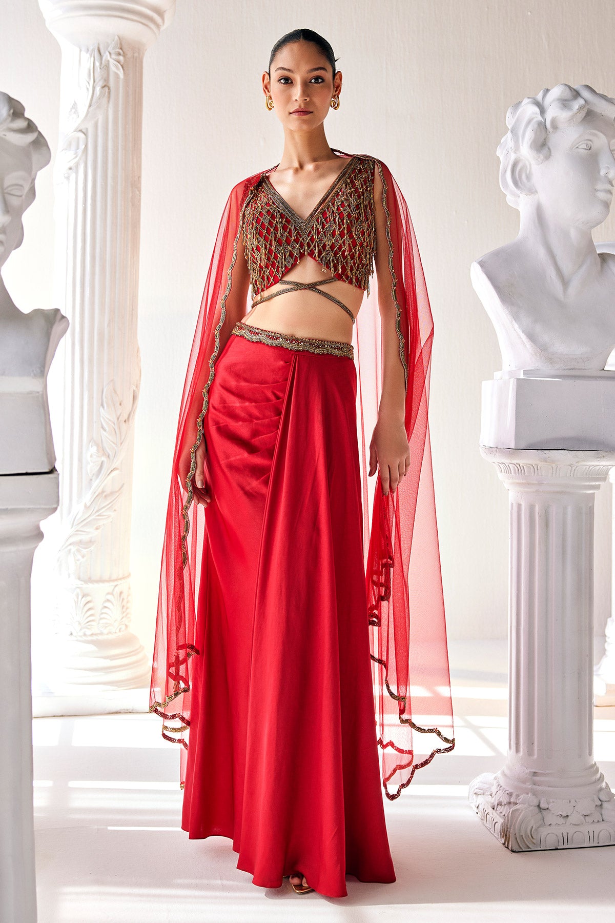 Elegant Red Ensemble Features A Royal Satin Skirt, Fully Embroidered Blouse, Belt And A Cape In A Soft Net.