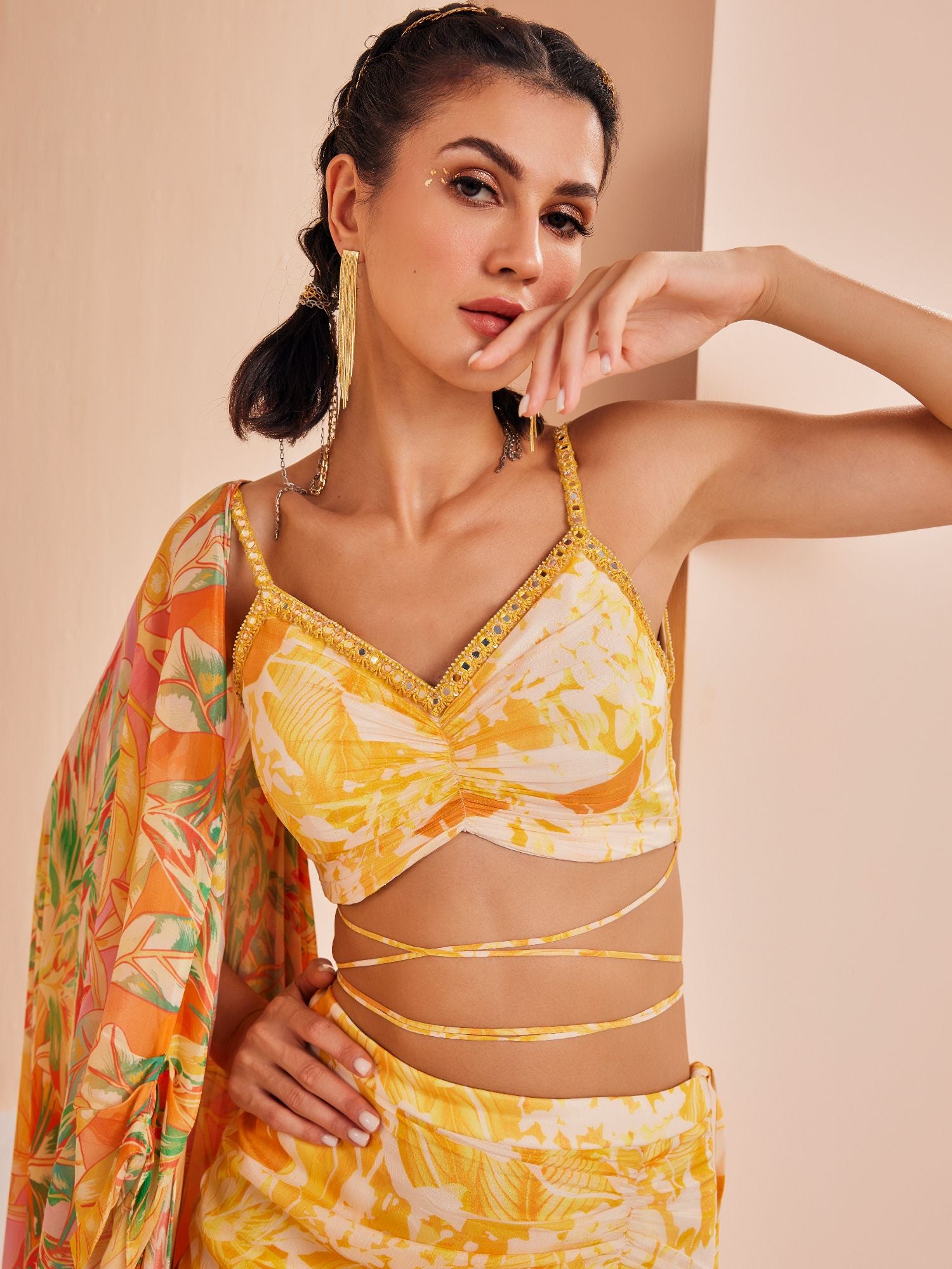 Fluorescent yellow printed blouse with draped asymmetric chiffon skirt stylized with a cape
