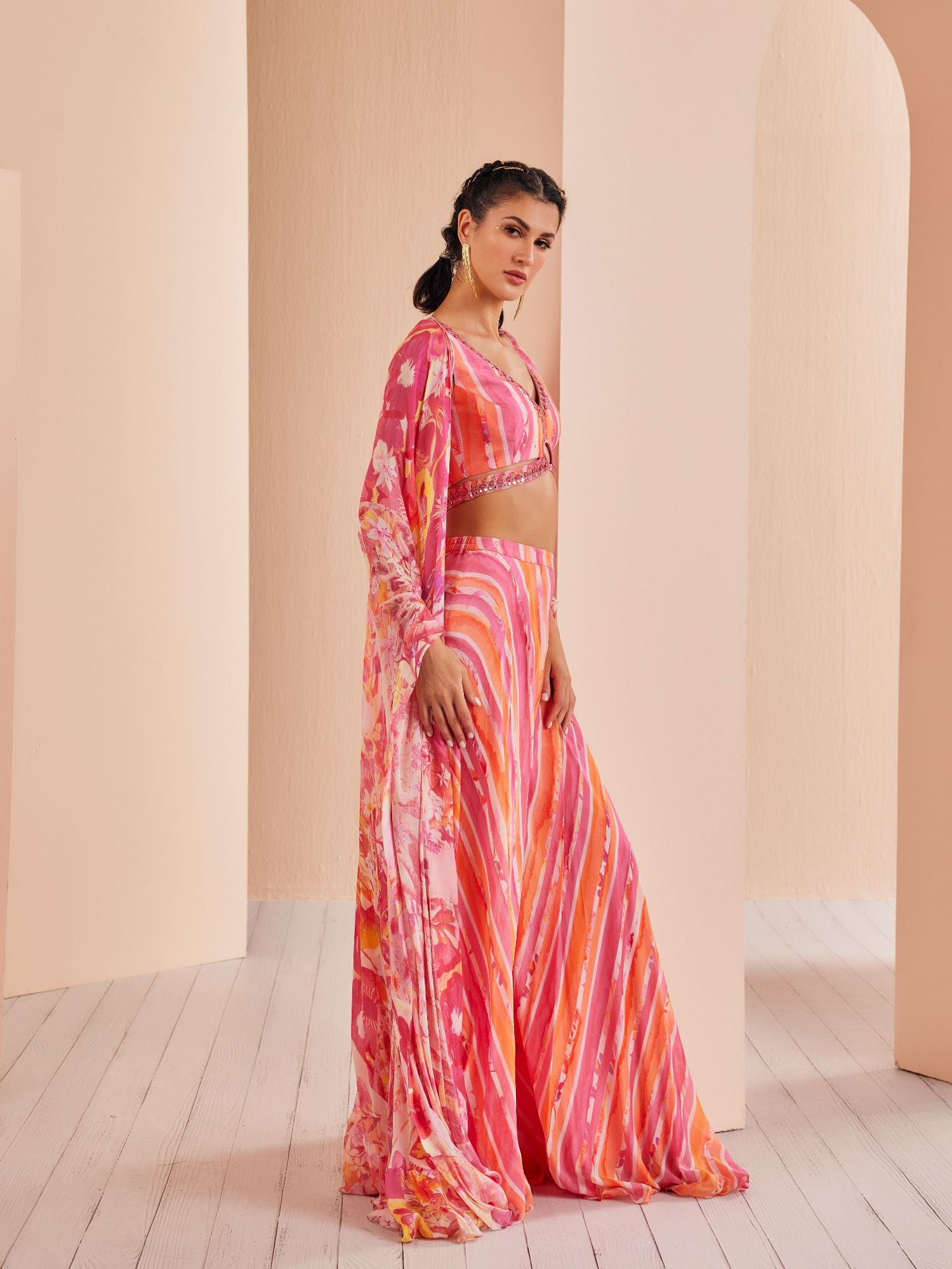 Pink Printed chiffon blouse stylized with gold ring with sharara and cape