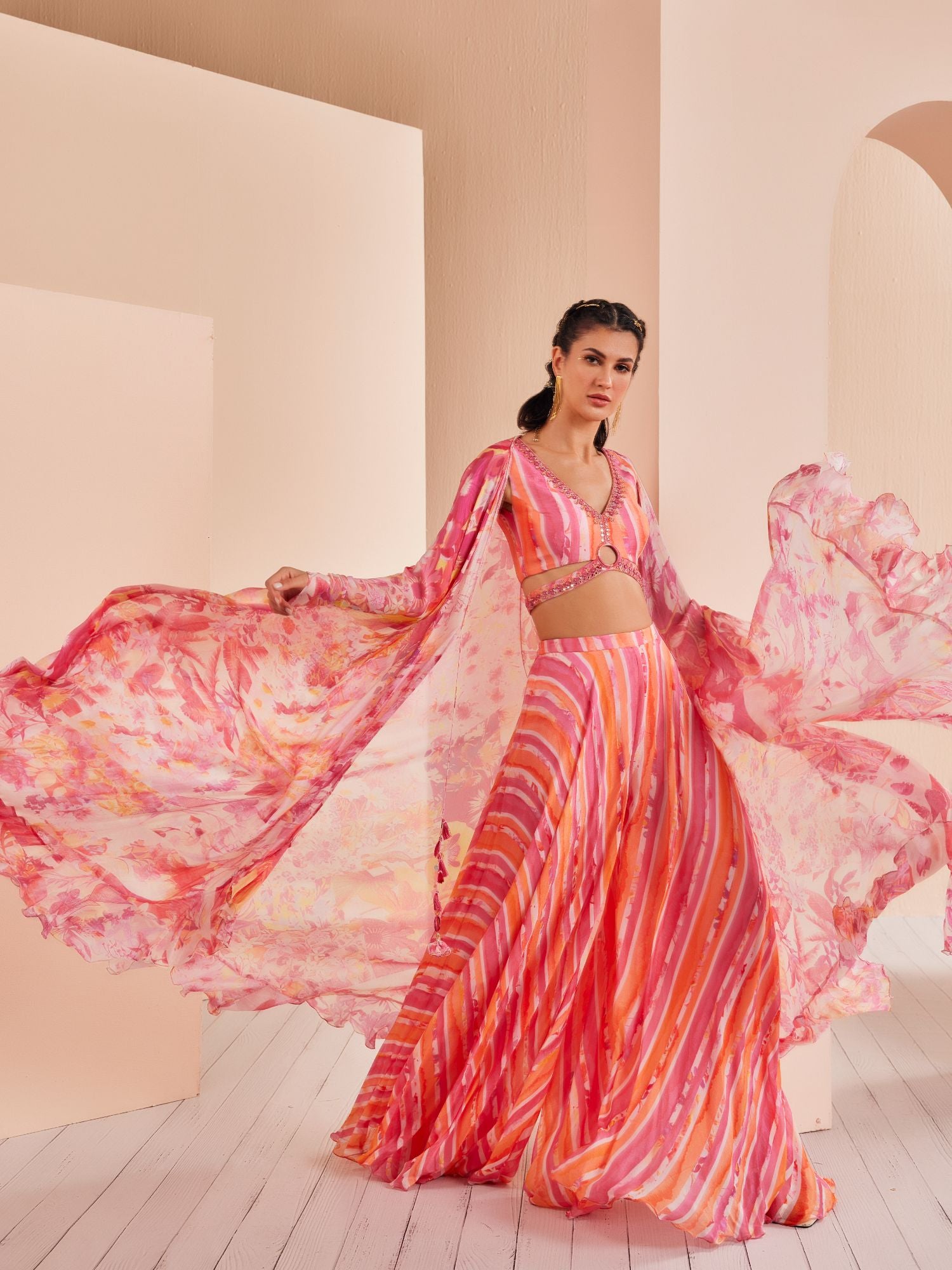 Pink Printed chiffon blouse stylized with gold ring with sharara and cape