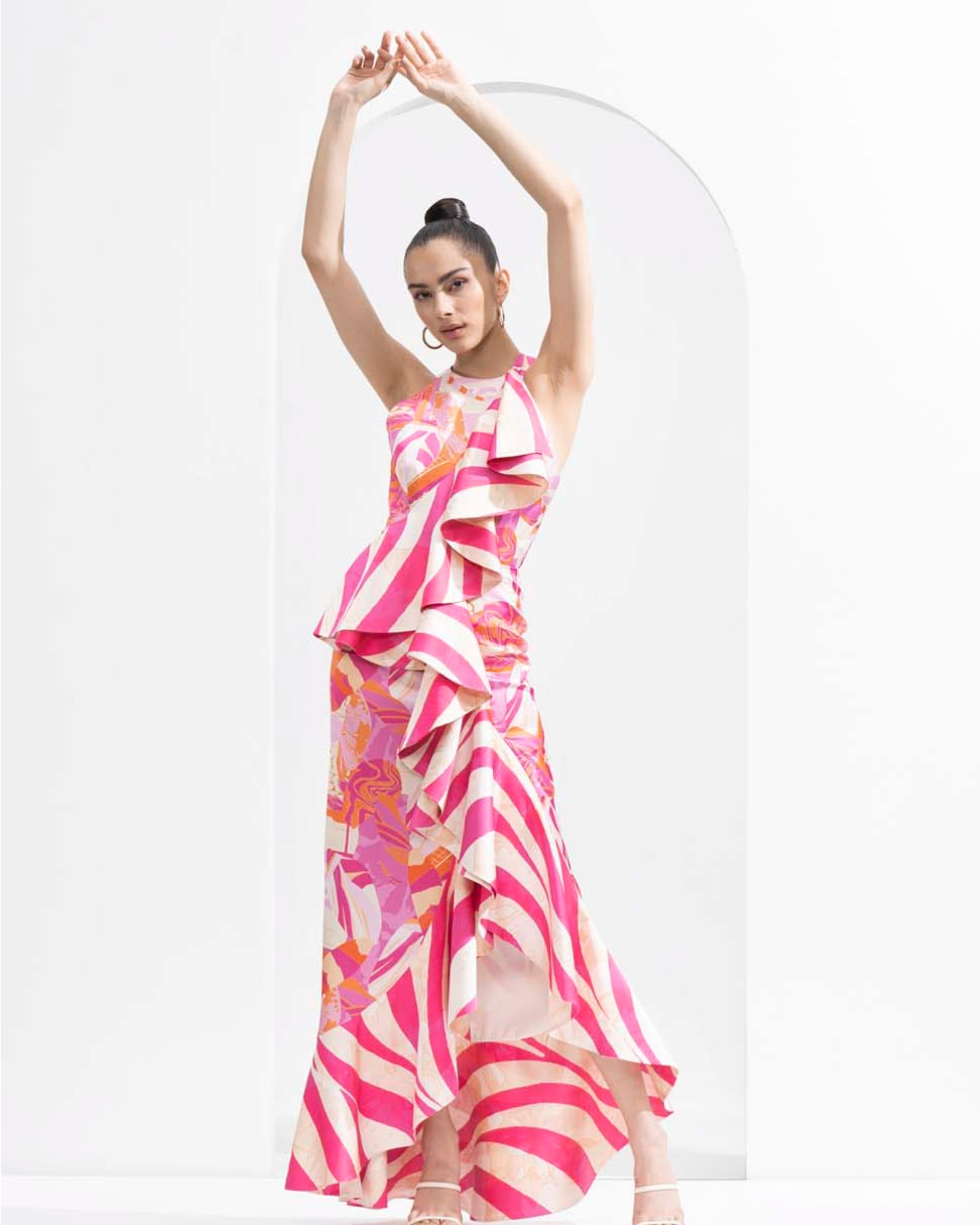 Pink abstract lustrous satin bodycon dress with an asymmetric frill and gold accessory.