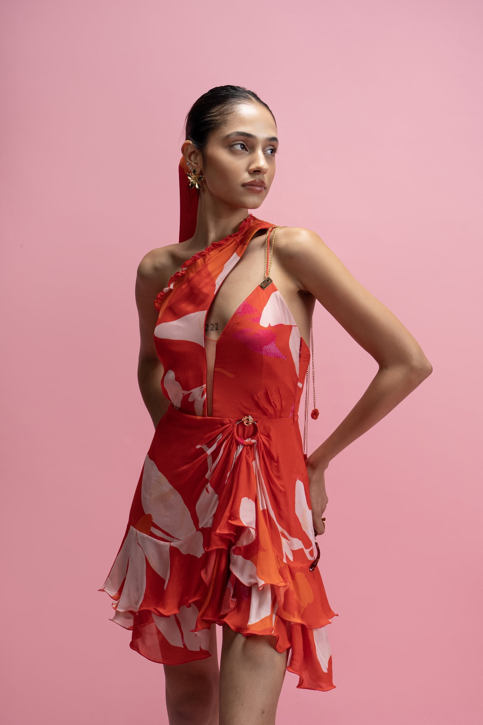Woman wearing a red and white dress against a pink background