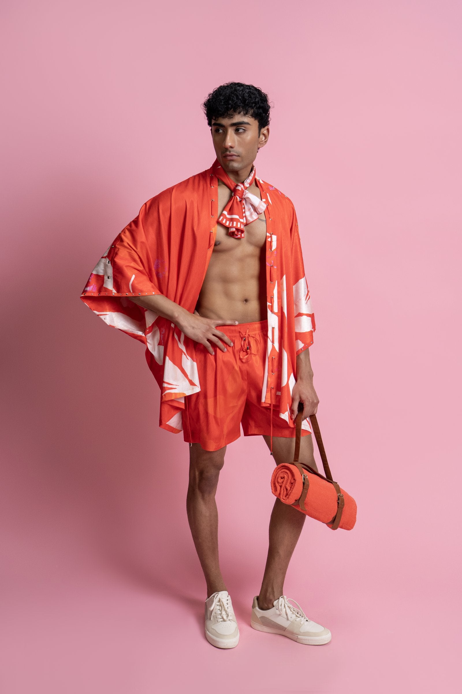 A relaxed menswear set featuring a placement print shirt paired with easy-fit shorts. The shirt is designed with a fluid, open silhouette and subtle rivet detailing
