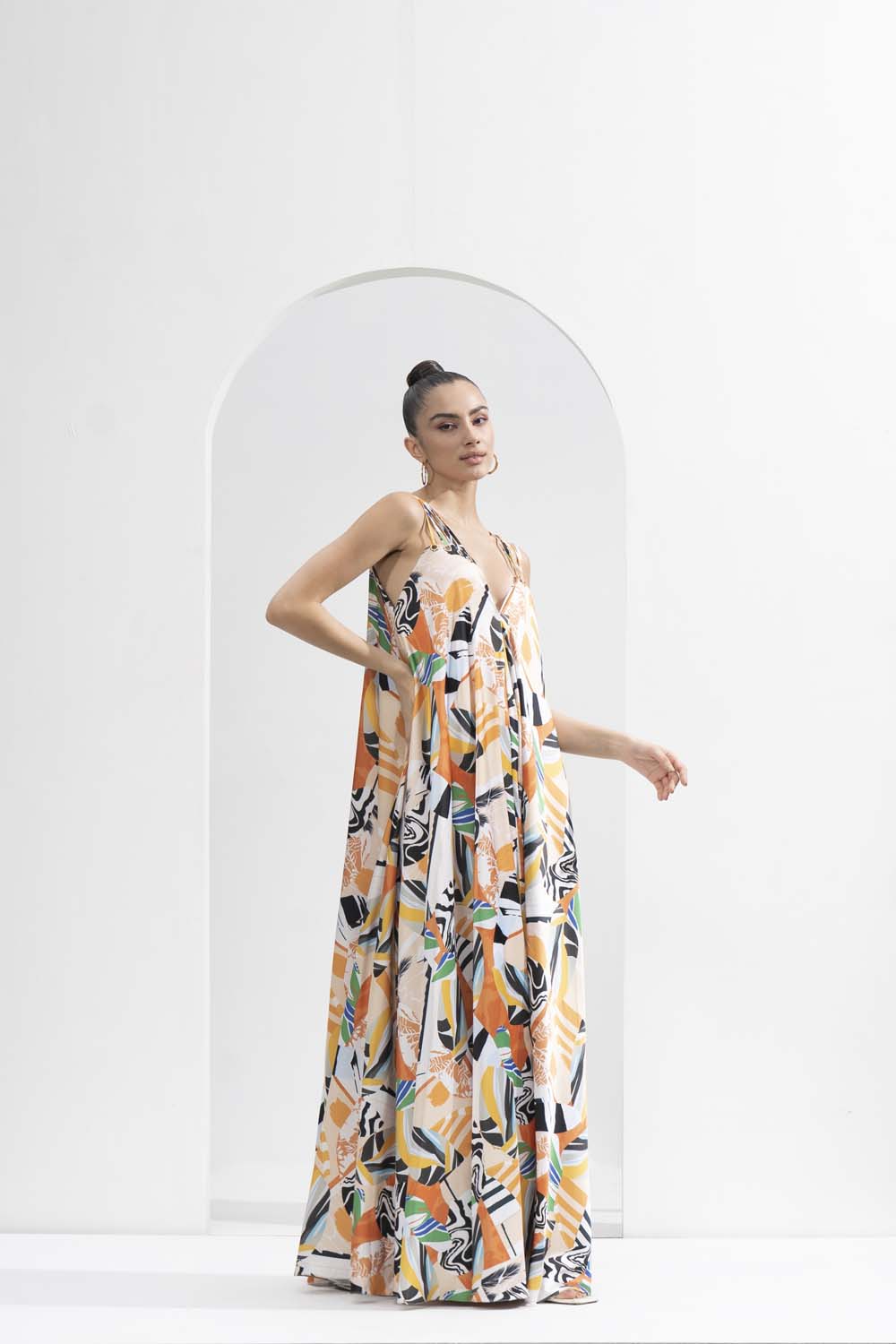 Yellow abstract satin printed long loose-fit dress with gold eyelet detailing.