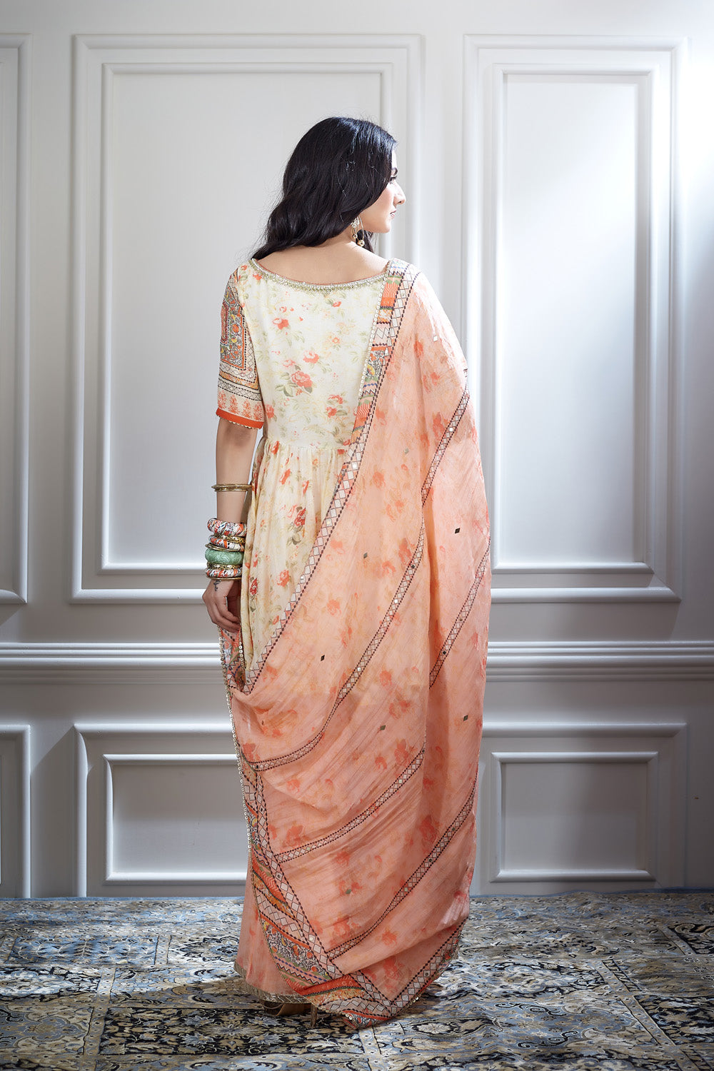 An ivory peplum tunic paired with a printed sharara and dupatta
